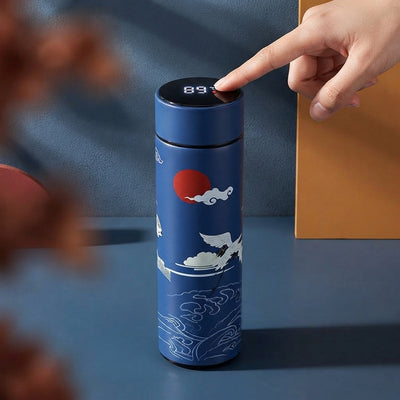 Retro smart stainless steel flask with a glowing digital temperature display on the lid, set against a sophisticated studio b